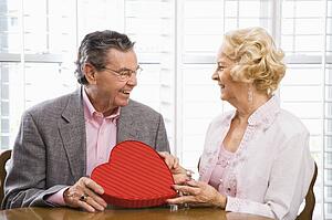 Man giving Valentine heart box to woman