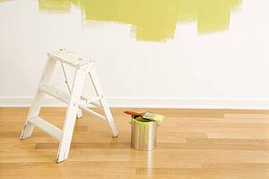 Still life of paintbrush on paint can with stepladder painted wall.