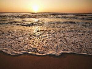 Crashing waves with sun setting