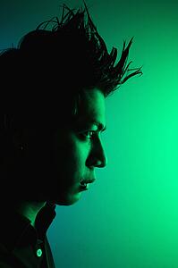 Side view of attractive young Asian man with spiked hair.