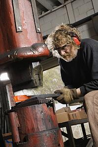 Caucasian man using power hammer.