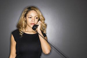 Woman holding telephone receiver to ear