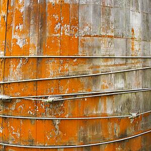 Close up of round structure with wood panels and peeling orange paint.