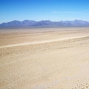 Aerial view of remote California desert with mountain range in background