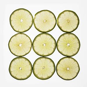 Lime slices arranged in square design on white background.