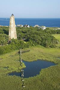Aerial view of Old Baldy lighthouse in marshy lowlands of Bald Head Island, North Carolina.