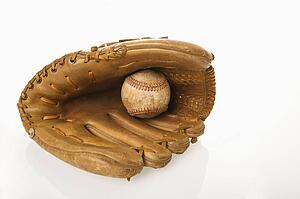 Baseball resting in baseball glove.