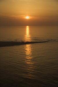 Sunset over ocean with breakwater