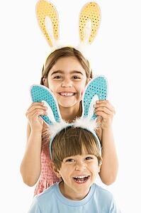 Boy and girl wearing rabbit ears smiling