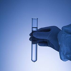 Hand holding test tube.