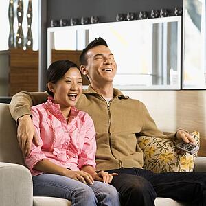 Couple laughing while watching television