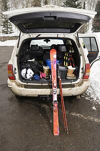 Rear view of automobile with back door open and ski equipment inside