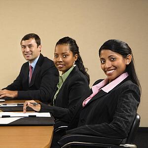 Businesspeople sitting at conference table smiling