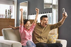 Couple cheering while watching television