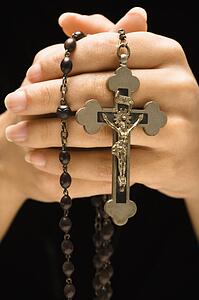 Woman holding rosary with crucifix