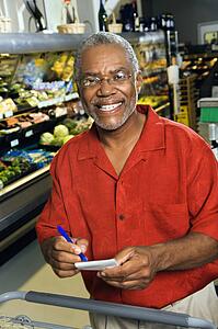 Man in grocery store holding shopping list