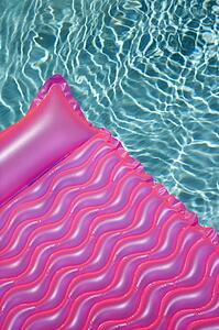 Pink float in empty swimming pool with rippling blue pool.