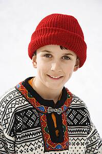 Portrait of boy wearing sweater and red winter cap