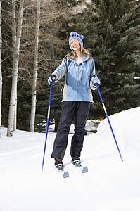 Skier standing on ski slope smiling