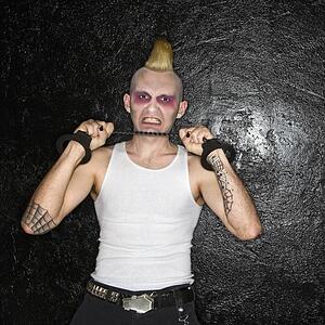 Mid-adult male punk pulling chain between handcuffs.