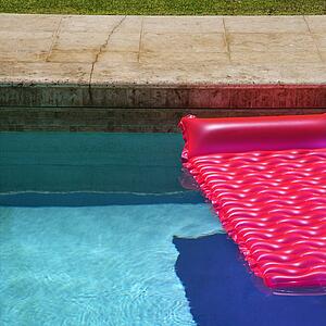 Pink float in empty swimming pool.