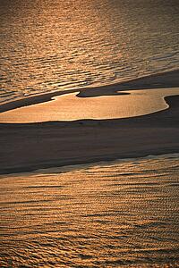 Aerial view of sun over Atlantic ocean and shoreline of Bald Head Island, North Carolina.