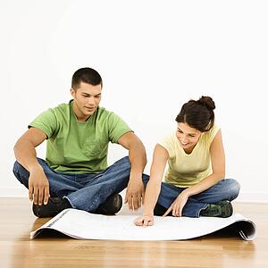 Attractive young adult couple looking at house plans.