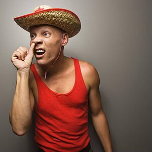 Male wearing straw hat with thumb up his nose