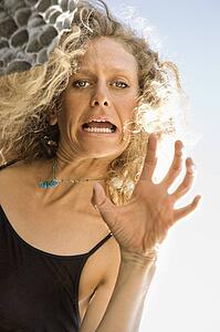 Low angle view of Caucasian mid-adult woman making facial expression and gesturing to viewer.