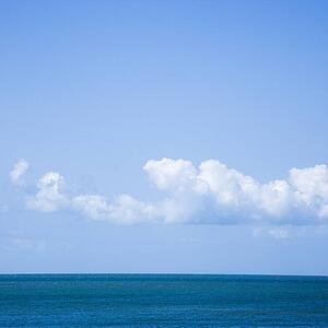 Ocean and sky with low cumulus clouds.