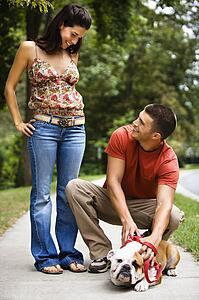 Couple on the sidewalk with their dog