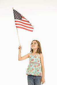 Girl holding American flag against white background.