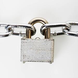 Metal padlock locked to chains