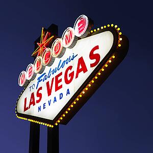 Lighted Las Vegas welcome sign with night sky.