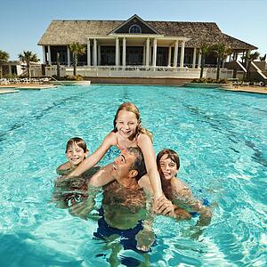 Family at pool with clubhouse in background