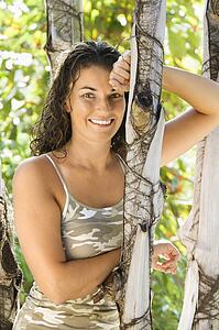 Woman leaning against tree 