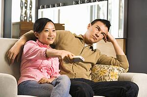 Female pointing remote while male looks annoyed
