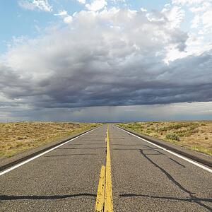 Empty two lane highway leading to desert horizon