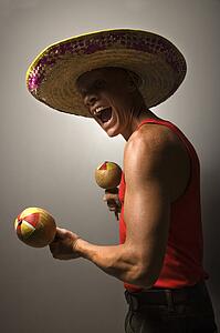 Male wearing sombrero holding maracas