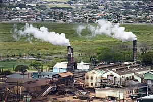 Factory smokestacks spouting white clouds