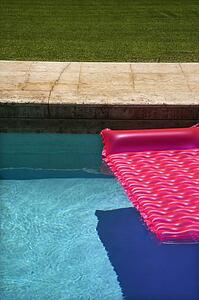 Pink float in empty swimming pool.