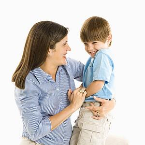Mother holding son laughing against white background