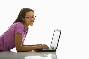 Woman lying on floor using laptop 