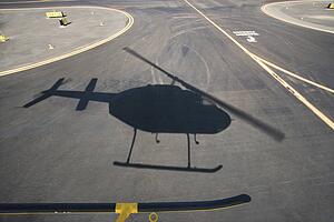 Aerial of helicopter shadow on airport runway pavement