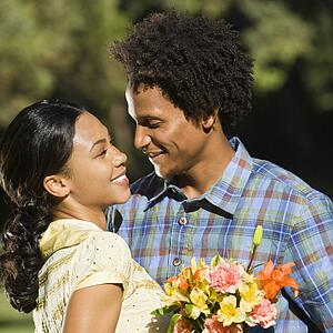 Woman embracing man with flowers