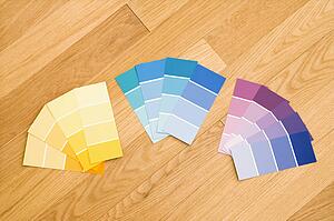 Paint color swatches grouped together by color on wood floor