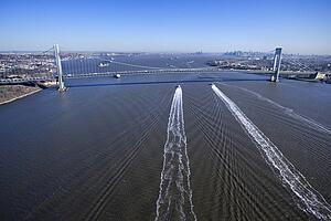 Aerial view of New York City's Verrazano-Narrow's Bridge with boats in water.