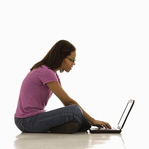 Woman sitting on floor using laptop