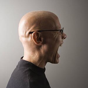 Profile portrait of mid-adult male screaming