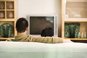 Couple sitting on couch watching TV